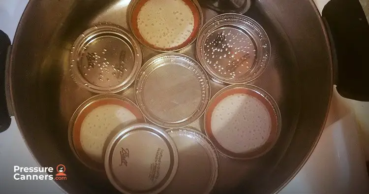 a pot with jar lids in water