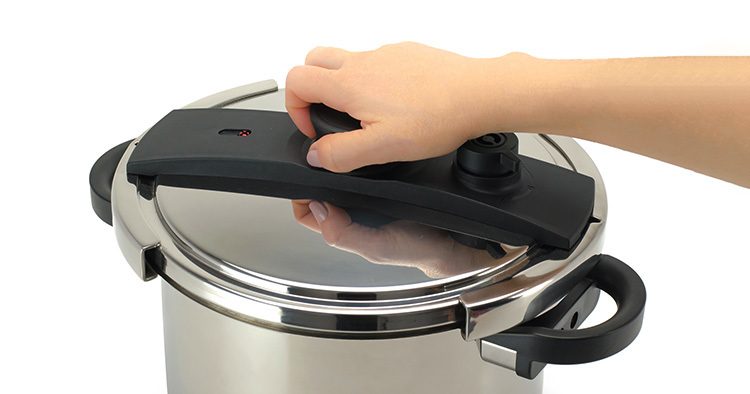 Woman holding the lid of a pressure canner