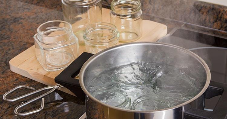 Boiling glass jars for sterilization and preparing homemade jam.