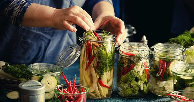 Elder woman canning vegetables