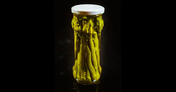 Green Asparagus Conserved in Glass Jar in Black Background
