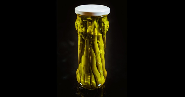 Green Asparagus Conserved in Glass Jar in Black Background
