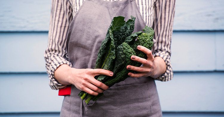 Closeup of Female Hands Holding Bunch of Green Italian Kale