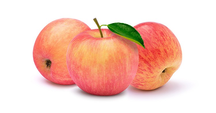 Closeup three whole pink fuji apples with green leaf isolated on white background