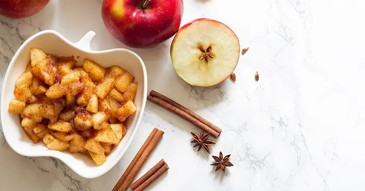 Apples, cinnamon and chunky applesauce on white background