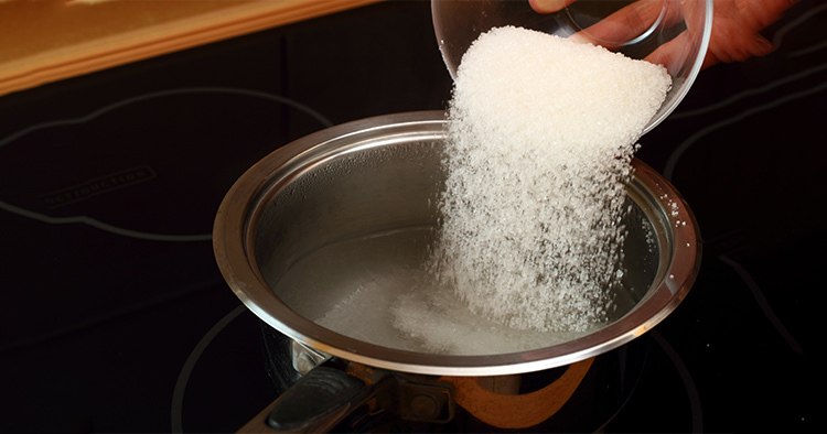 pouring-sugar-into-saucepan-boiling-water