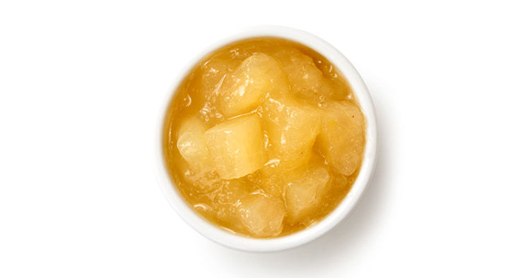 Bramley apple sauce in ceramic bowl isolated on white from above.