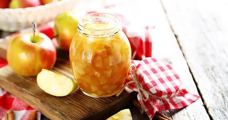 Apple jam in jar on a grey wooden table