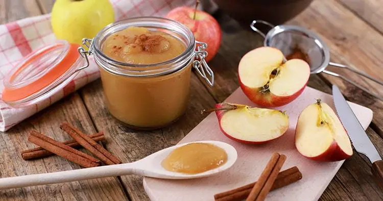 homemade apple jam, apple puree with fresh apples and spices on wooden rustic table