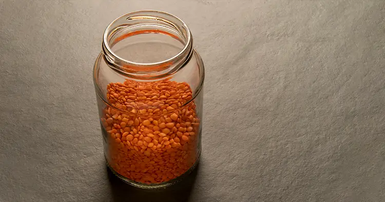 Lentils in a glass jar isolated on a gray table