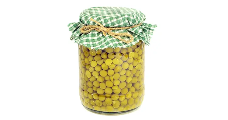canned green peas in glass jar on a white background