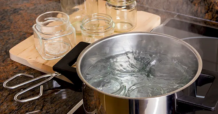 Boiling glass jars for sterilization and preparing homemade jam.