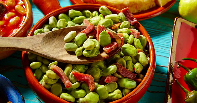 Tapas lima beans with iberico ham from Spain on wood