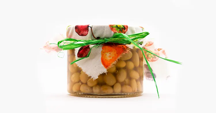 Delicious homemade canned Italian zolfini beans in a glass jar close up isolated on a white background