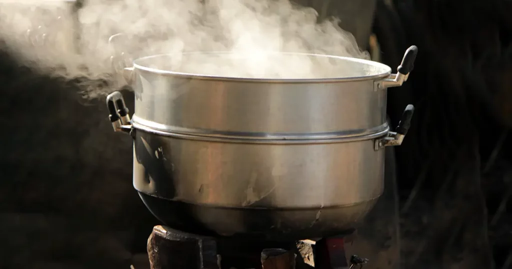 The steam drifting over the pot is cooking.