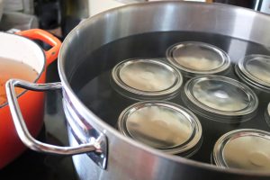 jars in a water-bath canner with water covering the jars