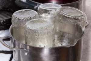 jars in a pan being steamed
